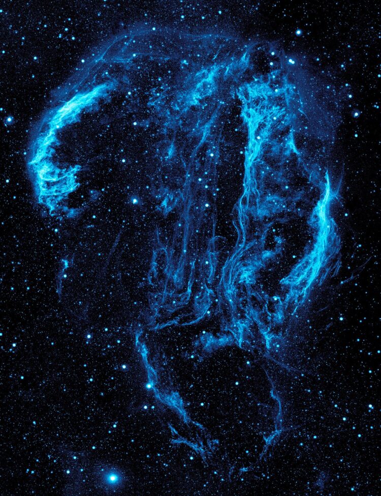 Wispy tendrils of hot dust and gas glow brightly in this ultraviolet image of the Cygnus Loop Nebula, taken by NASA’s Galaxy Evolution Explorer.