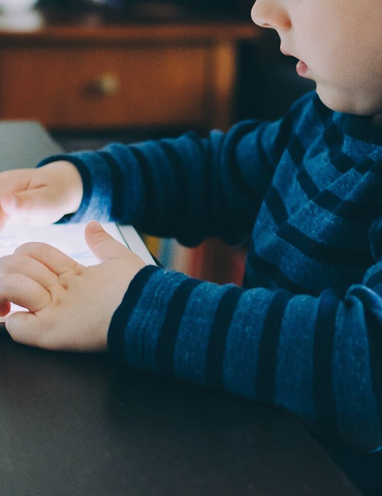 A child playing with an iPad while seated at a table
