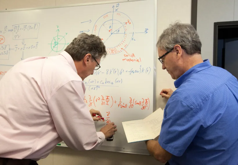 Physicists work on an equation