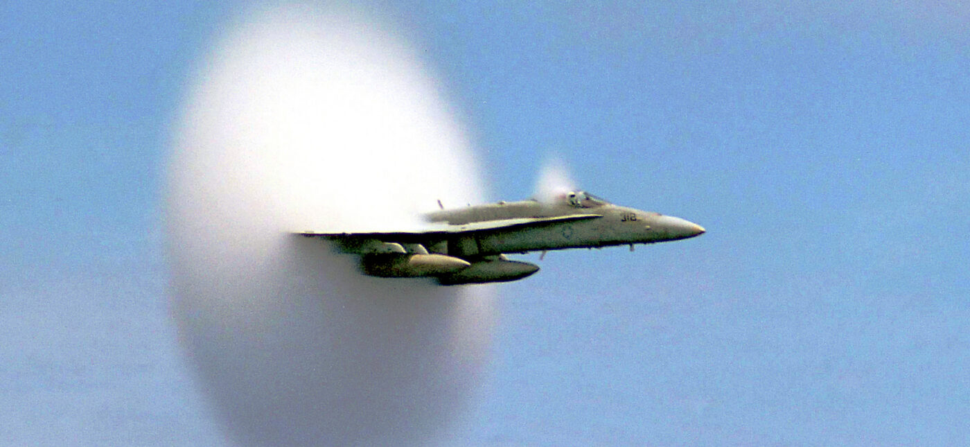 A cloud forms as this F/A-18 Hornet aircraft speeds up to supersonic speed.