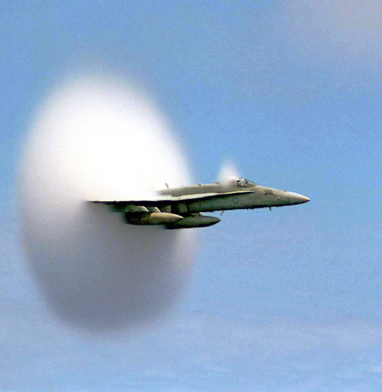 A cloud forms as this F/A-18 Hornet aircraft speeds up to supersonic speed.