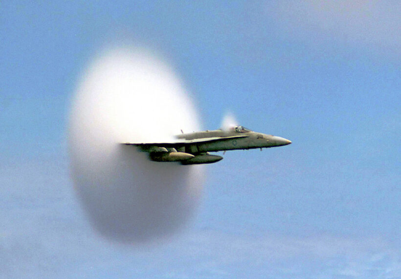 A cloud forms as this F/A-18 Hornet aircraft speeds up to supersonic speed.