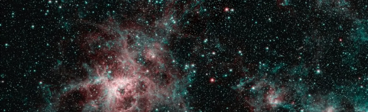 This image from NASA's Spitzer Space Telescope shows the Tarantula Nebula in two wavelengths of infrared light, each represented by a different color. The red color at the heart of the nebula shows the presence of particularly hot gas emitting infrared light at a wavelength of 4.5 micrometers. The blue regions are dust composed of molecules called polycyclic aromatic hydrocarbons (PAHs), which are also found in ash from coal, wood and oil fires on Earth. Regions emitting both wavelengths appear white.