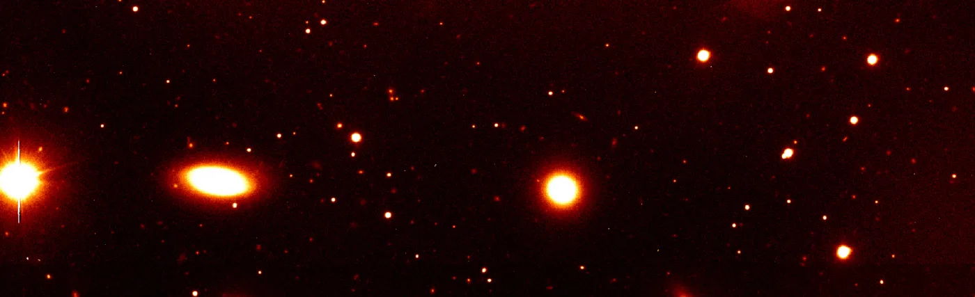 Nearby galaxy group RXCJ0937.9-2020 at a redshift of z = 0.034. It is dominated by the massive elliptical galaxy seen at the top of the image. The photo covers only the southern part of this group. Such galaxy groups with typical masses of a few 1013 solar masses constitute the smallest objects included in the REFLEX catalogue. This image was obtained with the FORS1 multi-mode instrument on the ESO 8.2-m VLT Antu telescope.