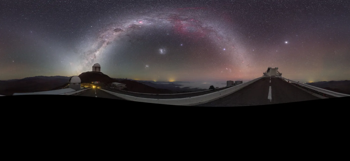 This striking image was captured using a fish-eye lens, giving it the distinctive look of a circular window, peering into a different world. Here the landscape at the [/public/teles-instr/lasilla/ La Silla] observatory in Chile can be seen wrapped around the edge, with the constellations of the Zodiac splashed across the early morning sky.